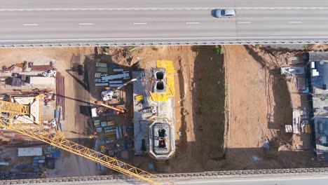 Workers-constructing-bridge-column-in-between-two-bridges,-aerial-top-down-view