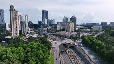 Cinematic-aerial-view-of-Buckhead-Atlanta-road-traffic-flow-with-skyline-buildings-in-background,-Georgia,-USA