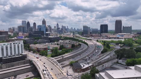 Scenic-aerial-view-of-Peachtree-Street-flowing-traffic-with-Downtown-Atlanta-skylines-in-background,-Georgia,-USA