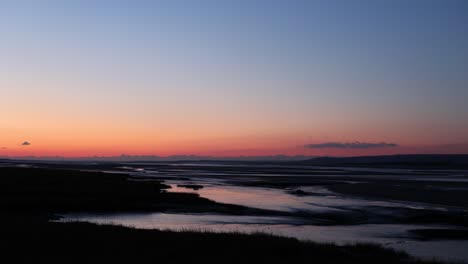 Aufnahme-Eines-Winterlichen-Sonnenuntergangshimmels-über-Einer-Flussmündung-Mit-50-Bildern-Pro-Sekunde-Und-Einem-Kleinen-Schiffswrack-Am-Ufer