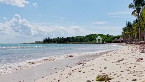 Wunderschöner-Strand-In-Tulum-In-Der-Nähe-Von-Cancun,-Mexiko,-Mit-Kleinen-Wellen,-Palmen,-Blauem-Himmel-Und-Einigen-Wolken
