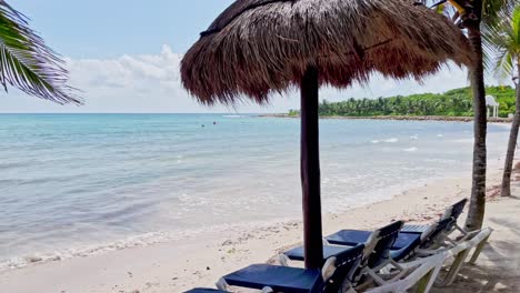 Wunderschöner-Strand-In-Tulum-In-Der-Nähe-Von-Cancun,-Mexiko,-Mit-Cabanas,-Stühlen,-Kleinen-Wellen,-Palmen,-Blauem-Himmel-Und-Einigen-Wolken