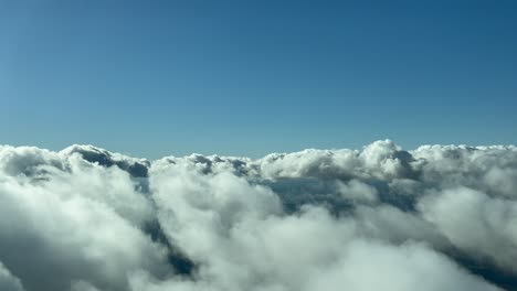 Flying-across-a-clouded-sky-with-some-fluffy-clouds,-as-seen-by-the-pilots