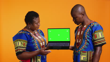 Personas-étnicas-Que-Presentan-Una-Computadora-Portátil-Con-Diseño-De-Pantalla-Verde