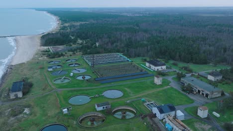 Establishing-aerial-view-of-water-basins-at-the-sewage-treatment-plant,-ponds-for-recycling-dirty-wastewater,-recycle-system-technology,-waste-management-theme,-drone-shot-moving-forward,-tilt-down