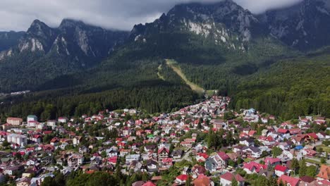 Vibrant-town-facing-surreal-Carpathian-mountain-in-Transylvania,-Romania