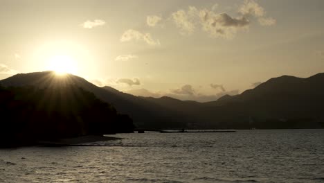 Ruhiger-Sonnenuntergang-Zur-Goldenen-Stunde-Mit-Sonneneruptionen-Hinter-Den-Bergen-Mit-Blick-Auf-Die-Bucht-Von-Hiroshima
