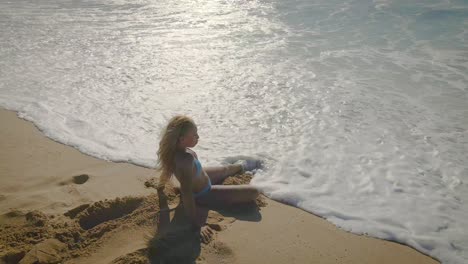 Ruhe-Am-Strand:-Eine-Junge-Frau-Im-Blauen-Bikini-Findet-Freude-An-Der-Einfachheit-Des-Strandurlaubs-Und-Zeigt-Die-Essenz-Des-Reisens-Und-Tourismus-An-Diesem-Tropischen-Ort