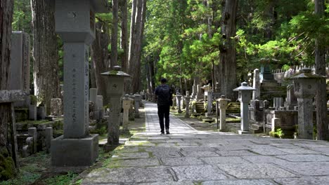 Solo-Male-Backpacker-Walking-Through-Okunoin-Forest-Cemetery-In-Wakayama