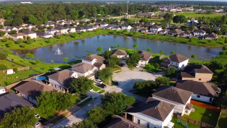 An-aerial-lake-view-of-a-community-of-houses,-located-in-the-suburbs,-at-60-frames