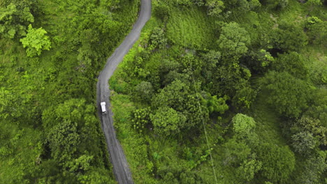 aerial-of-4x4-jeep-touring-car-driving-off-road-crossing-jungle-green-deep-vegetation-exploring-Costa-Rica