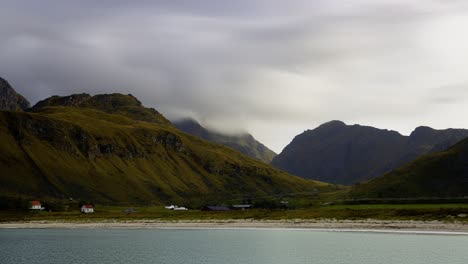 Vista-De-Un-Pequeño-Pueblo-En-Un-Valle-Junto-Al-Mar-Abierto,-Islas-Lofoten,-Norte-De-Noruega