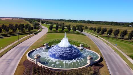 An-aerial-shot-of-a-community-water-fountain,-on-a-sunny-day,-at-60-frames
