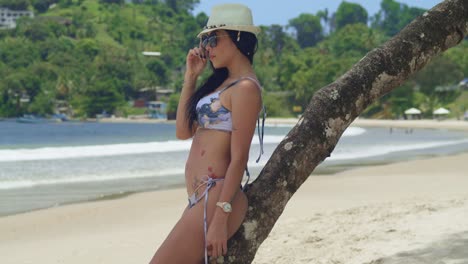 Enjoying-the-warmth-of-a-Caribbean-beach,-a-girl-in-a-bikini-takes-in-the-white-sandy-surroundings