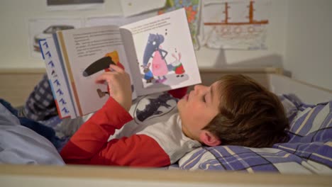 Medium-side-view-of-caucasian-boy-reading-a-fairytale-before-sleep-4K