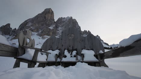 Wooden-Carved-Chairs-Covered-In-Snow-At-The-Cabins-Near-Sass-de-Putia-Mountain-Hike-In-South-Tyrol,-Italy