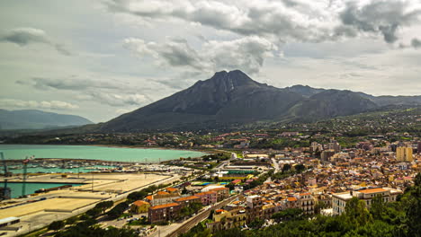 The-beauty-of-Sicily-is-brought-to-life-in-a-landscape-time-lapse-view-that-showcases-clouds-cascading-over-the-mountains,-colorful-houses,-and-the-serene-ocean