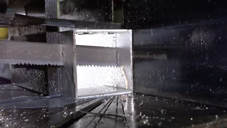 Band-saw-sawing-through-a-aluminum-shaped-pipe-with-cooling-fluid-in-super-slow-motion-800fps