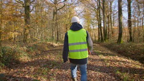 Walking-through-countryside,-contractor,-high-visibility-jacket.-Slow-mo