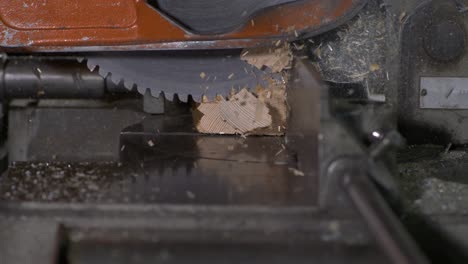 wood-chips-flying-everywhere-while-a-saw-stops-during-cutting-a-wood-block-in-super-slow-motion