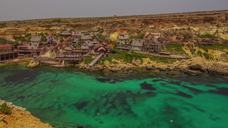 A-visually-captivating-time-lapse-video-showcases-the-enchanting-Popeye-Village's-theme-park,-adorned-with-a-picturesque-green-lake-and-charming-houses-nestled-gracefully-around-its-scenic-shores