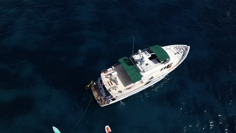 Aerial-Drone-footage-of-Yacht-in-the-Sea,-Malta-Beach,-people-having-fun