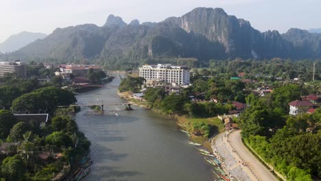 Luftaufnahme-Des-Sonnenaufgangs-über-Dem-Fluss-Nam-Song-Mit-Dem-Hotel-Im-Hintergrund-In-Vang-Vieng