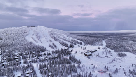 Aerial-view-approaching-the-Iso-Syote-ski-center,-vibrant-winter-evening-in-Finland