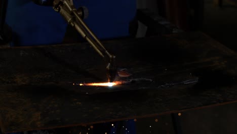 oxyfuel-cutting-a-piece-of-metal-in-super-slow-motion-with-industrial-background