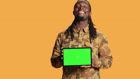 Male-model-holding-laptop-with-greenscreen-layout-in-studio