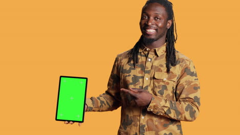 African-american-man-presents-greenscreen-on-tablet