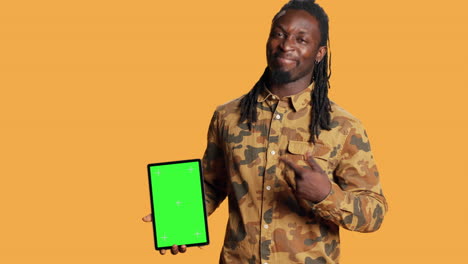 African-american-guy-shows-greenscreen-on-tablet
