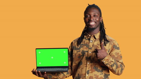 Person-having-laptop-with-greenscreen-display-on-camera