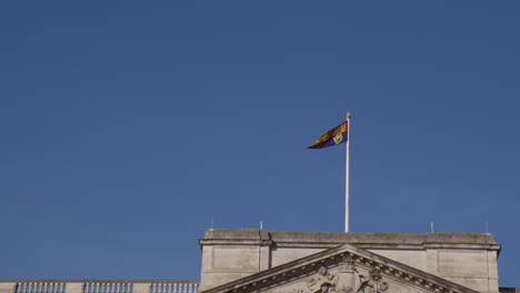 Ondeando-La-Bandera-En-El-Cielo-Azul-Sobre-El-Palacio-De-Buckingham-En-Londres,-Inglaterra,-Reino-Unido