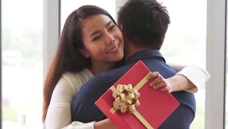 Romantic-couple-giving-gift-to-lover-at-restaurant