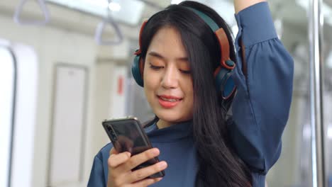 Young-woman-using-mobile-phone-on-public-train