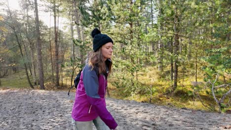 Handheld-tracking-shot-of-woman-walking-in-forest-on-sunny-day