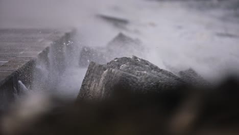 Shallow-focus-shot-over-breakwater-as-stormy-winds-blow-sea-spray-and-spume