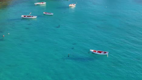 Drohnenfilm-Dolly-Neigt-Sich-Zu-Fischerbooten,-Die-Im-Klaren-Karibischen-Wasser-Von-Boca-Sami,-Curacao,-Vor-Anker-Liegen
