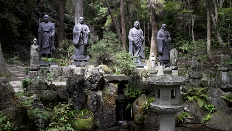 Fila-De-Estatuas-En-El-Templo-Mitaki-Dera-En-Un-Entorno-Forestal.