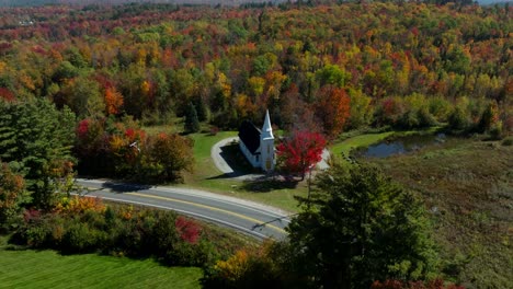 Drone-footage-of-a-church-in-New-Hampshire-surrounded-with-autumn-colored-trees
