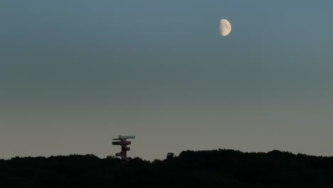Media-Luna-Brillante-Sobre-La-Silueta-De-La-Torre-Wilhemina,-Oscuridad-De-La-Noche