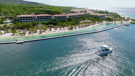 Yacht-drives-past-exclusive-Santa-Barbara-beach-on-sunny-day,-Curacao