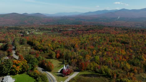 Aerial-view-of-a-church-surrounded-with-fall-foliage-in-New-Hampshire