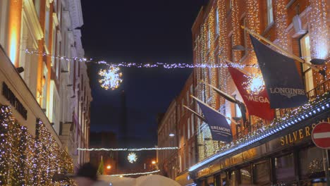 Low-angle-shot-of-Christmas-lights-on-the-outer-walls-of-houses-in-the-heart-of-Dublin,-Ireland-at-night-time