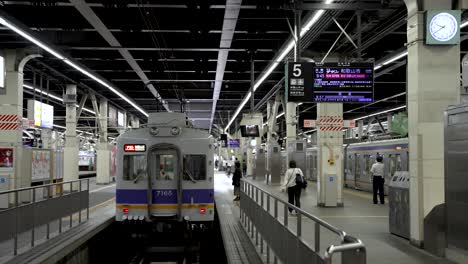 Commuters-Walking-Along-Platform-Number-5-At-Namba-Station-With-Train-Waiting