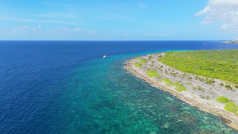 Panoramic-aerial-overview-push-in-to-dive-boat-anchored-near-stunning-beautiful-reef-in-Curacao