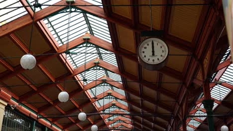 Clock-hang-from-ceiling-at-Masaryk-railway-station-interior-at-noon,-Prague