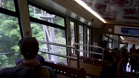 Dentro-Del-Cable-Koyasan-Bajando-Hacia-Gokurakubashi-Con-Turistas-Mirando-Por-La-Ventana