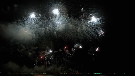 White-explosions-like-clouds,-silver-colored-fireworks-and-in-the-bottom-some-small-sequences
